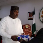 The Dean of the Faculty of Management and Social Sciences of Godfrey Okoye University, Professor Onyema Ocheoha, presents his report as Chairman of the Ad hoc Committee on Civil Service Reform to the Governor of Enugu State, Dr. Lawrence Ifeanyi Ugwuanyi.