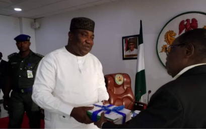 The Dean of the Faculty of Management and Social Sciences of Godfrey Okoye University, Professor Onyema Ocheoha, presents his report as Chairman of the Ad hoc Committee on Civil Service Reform to the Governor of Enugu State, Dr. Lawrence Ifeanyi Ugwuanyi.