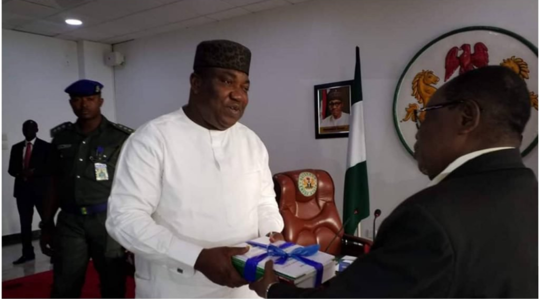 The Dean of the Faculty of Management and Social Sciences of Godfrey Okoye University, Professor Onyema Ocheoha, presents his report as Chairman of the Ad hoc Committee on Civil Service Reform to the Governor of Enugu State, Dr. Lawrence Ifeanyi Ugwuanyi.